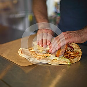 Close Up Of Man Making Takeaway Wrap In Food Van At Outdoors Summer Music Festival