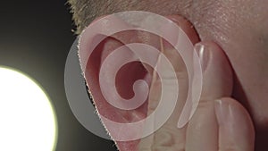 Close up of man massage his ear with visuable pulse