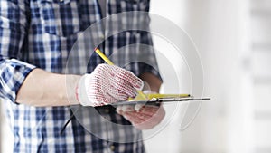 Close up of man with measuring ruler and clipboard