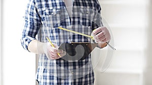 Close up of man with measuring ruler and clipboard