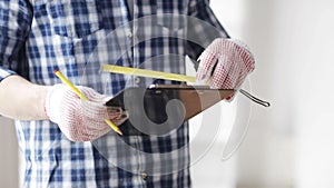 Close up of man with measuring ruler and clipboard