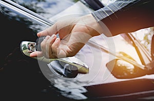 Close-up of man opening a car door. Hand on handle.