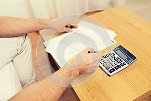Close up of man with papers and calculator at home