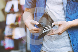 Close up man person holding an empty wallet in the hands of an man no money out of pocket