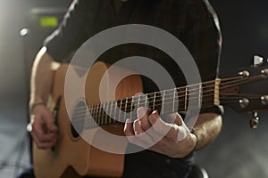 Close Up Of Man Playing Acoustic Guitar In Studio