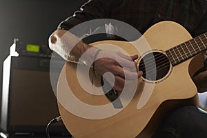 Close Up Of Man Playing Amplified Acoustic Guitar