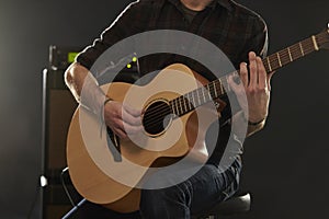 Close Up Of Man Playing Amplified Acoustic Guitar