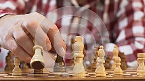 Close-up man playing chess and making checkmate to his opponent, leisure time