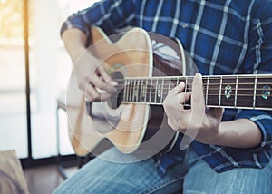 close up of a man playing guitar wih window light photo