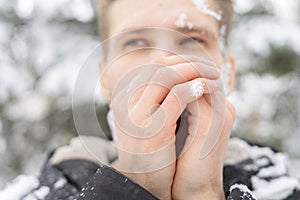 Close up man portrait warm up and heating hands near mouth outdoors on a winter day f