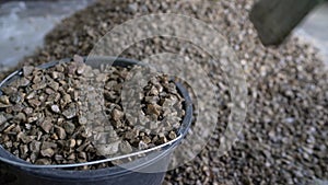 Close-up of a man pouring rubble. Sale of crushed stone. Crushed stone is poured into a bucket.