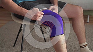 Close up of a man preparing for training, with a bandage on his knee slow mo