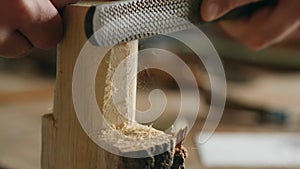 Close-up. a man processes a piece of wood with a file. the sound of carpentry tools. work with hand carpentry tools. art of