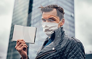 Close up. a man in a protective mask showing his passport.