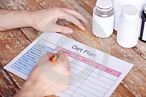 Close up of man with protein jars and diet plan