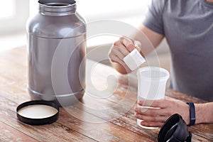 Close up of man with protein shake bottle and jar