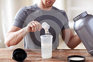 Close up of man with protein shake bottle and jar