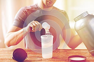 Close up of man with protein shake bottle and jar