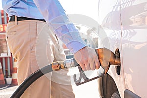 Close up man pumping gas. Car refueling on petrol station