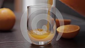 Close up of man pur orange juice in glass