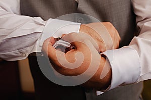 CLose up of  man putting on a cuffling on white dress shirt