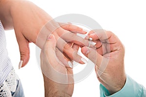 Close up of man putting engagement ring on girlfriend finger