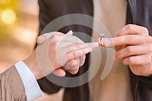CLose up of man putting ring on female finger