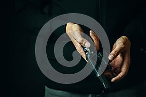 Close up of man reloading revolver.