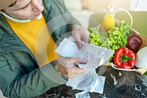 Close-up of Man Reviewing Grocery Receipts