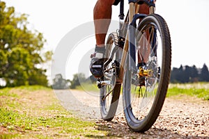 Close Up Of Man Riding Mountain Bike On Countryside Path