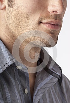 Close-up of man`s chin and jawline with facial hair beard stubble five o`clock shadow. Men`s personal care and grooming