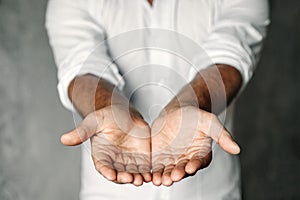 Close up of man`s cupped hands show something on white background. Palms up. High resolution product