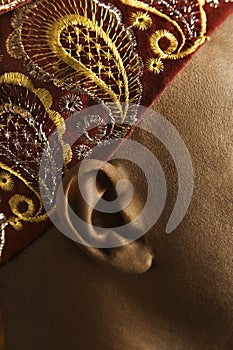 Close-up of man's ear and African hat.