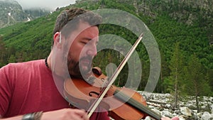 Close up of man`s face playing violin. Stylish musician playing classical music.