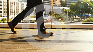 Close up of man`s feet walk on pedestrian crossing on a busy day in the center of the city on a sunny day on the road on