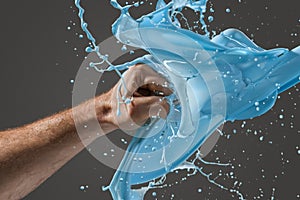 Close-up of a man's fist punching through liquid