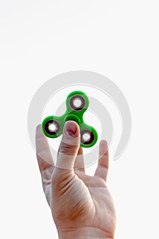 Close up of a man`s hand with green fidget spinner