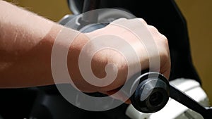 Close-up of man`s hand on handlebars of motorcycle.