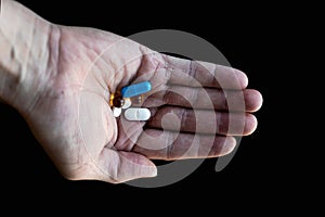 Close-up of a man`s hand holding different tablets in the palm