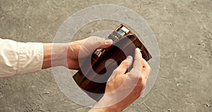 Close-up of a man's hand holding Leather Wallet Empty with No Money. The concept of poverty.