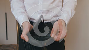 Close-up of a man`s hand holding Leather Wallet Empty with No Money. The concept of poverty. Businessman in white shirt