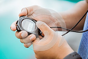 close up of a man& x27;s hand holding and setting a stopwatch