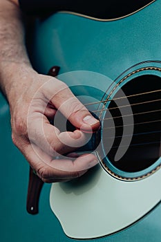 Close up of man's hand playing acoustic guitar. Concept of music