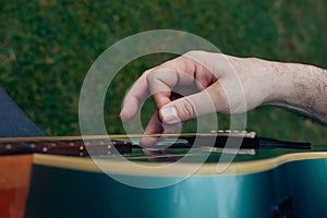 Close up of man's hand playing acoustic guitar. Musical instrument concept