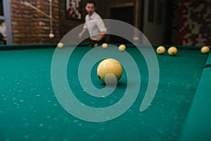 Close-up of a man& x27;s hand playing billiard on a green pool table