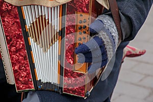 Close-up of a man's hand playing button accordion outdoors in winter