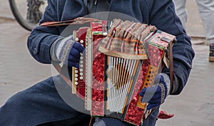 Close-up of a man's hand playing button accordion outdoors in winter
