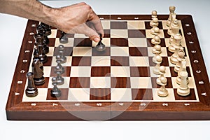 Close-up Of Man`s Hand Playing The Chess Game Board