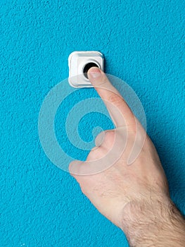 Close-up of man`s hand pressing the button of doorbell