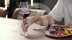 Close-up, a man's hand takes a glass of wine.